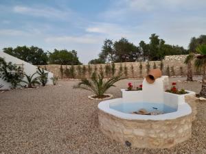 a stone fountain in the middle of a garden at le Doux refuge 2 in Essaouira