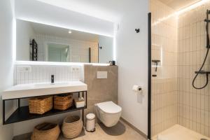 a bathroom with a sink and a toilet and a mirror at Stijlvol & lichtrijk Penthouse app met parking in Knokke-Heist +13 photos