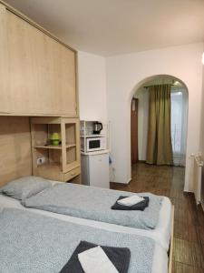 a room with two beds and a kitchen in it at Borbarátok Háza in Győr