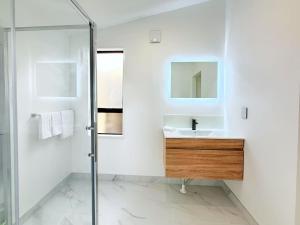 ロトルアにあるUnit 1, Fenton Summer Lodgeの洗面台と鏡のある白いバスルーム