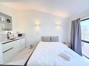 ロトルアにあるUnit 1, Fenton Summer Lodgeの白いベッドルーム(大型ベッド1台、窓付)