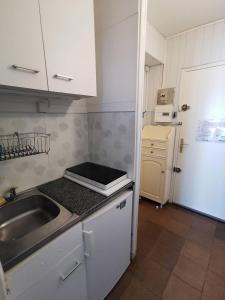 une petite cuisine avec un évier et un réfrigérateur dans l'établissement AS18262 - Studio en Centre Ville, au Grau-du-Roi 4 autres photos