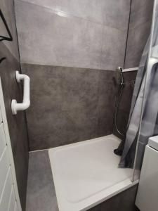 une petite douche avec un banc blanc dans une salle de bain dans l'établissement AS18262 - Studio en Centre Ville, au Grau-du-Roi