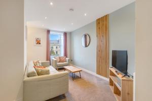 a living room with a couch and a tv at Earl Grey at The Tea Warehouse - North East Escapes in Alnwick
