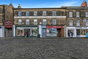 an empty street in front of a brick building at Earl Grey at The Tea Warehouse - North East Escapes in Alnwick