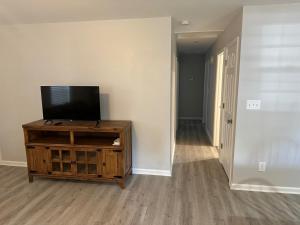 a living room with a flat screen tv on a wooden cabinet at The Lexington Wall, Lexington nc in Lexington