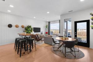 Una sala de estar con mesas y sillas y un sofá. en Luxury Riverview Condo with Patio Walk to Broadway, en Nashville