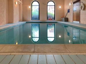 a swimming pool in a building with windows at The Mill Retreat in Stirling