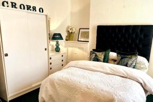 a bedroom with a large bed with a black headboard at Cosy Flat in Y Felinheli in Y Felinheli