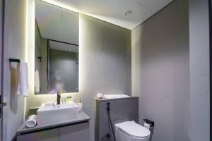 a bathroom with a sink and a toilet and a mirror at 017 - Mag 900 in Umm Al Quwain
