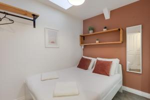 Un dormitorio con una cama blanca en una habitación. en Ceylon at The Tea Warehouse - North East Escapes, en Alnwick