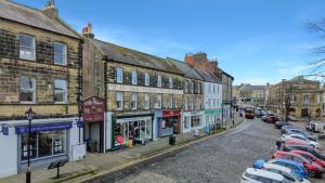 a city street with cars parked in a parking lot at Chai at The Tea Warehouse - North East Escapes in Alnwick