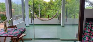a room with a hammock on a screened in porch at Casa Zero Sete - Praia de Algodões - Apto Árvores in Marau