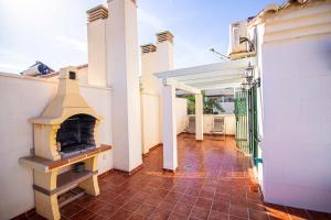 patio z kominkiem na świeżym powietrzu w domu w obiekcie Villa Cañada torremolinos w mieście Torremolinos