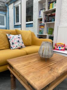 a yellow couch in a living room with a wooden coffee table at Number Forty Two, Portsoy - A 3 bedroom cottage with sea views in Portsoy
