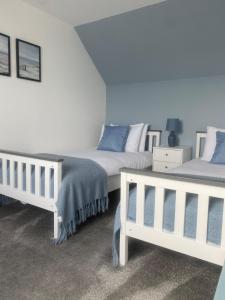 two beds sitting next to each other in a bedroom at Number Forty Two, Portsoy - A 3 bedroom cottage with sea views in Portsoy