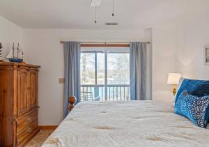 a bedroom with a bed and a large window at Lucky Dozen Lakehouse in Winchester