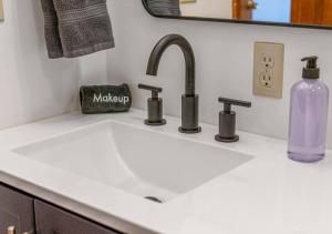 a white sink with a bottle of soap and a mirror at Lucky Dozen Lakehouse in Winchester +68 photos