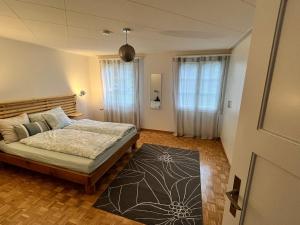 a bedroom with a bed and a rug at Chaletwohnung im Luzerner Seetal mit Platz, Charm und Erholungswert in Ballwil