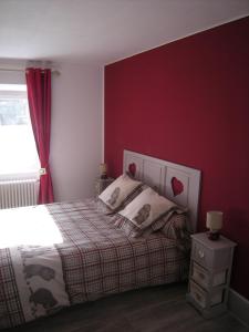 a bedroom with a bed and a red wall at Hotel gites des touristes in Vollore-Montagne