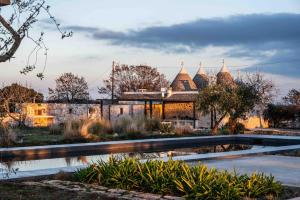 a house with a pond in front of it at Trulli Mansueto in Noci