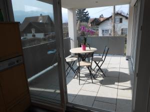 a patio with a table and chairs on a balcony at Ferienwohnung Daniela in Höchst