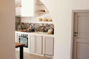 a kitchen with white cabinets and a sink at Trulli Mansueto in Noci