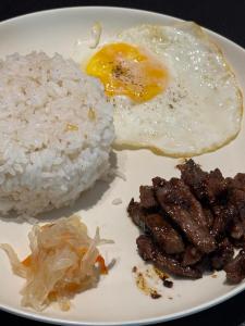 a plate of food with rice and an egg and meat at Lakandiwa Tourist Inn in El Nido +30 photos