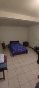 Un dormitorio con una cama y suelo de baldosas. en Casa 11 septiembre primera etapa, en Arica