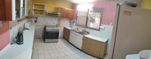 Una pequeña cocina con fregadero y refrigerador. en Casa 11 septiembre primera etapa, en Arica