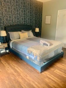 a bedroom with a bed with a blue bed frame at Queen Suite - Private Entrance - WiFi in Morrow