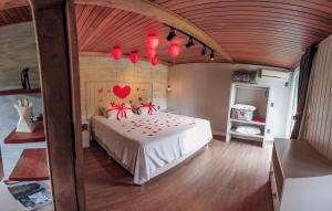 a bedroom with a bed with red hearts on the wall at Pousada do Imigrante in Pomerode