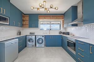 - une cuisine avec des placards bleus et un lave-linge/sèche-linge dans l'établissement Ultra Luxury 3 Bed Knightsbridge Penthouse, au Cap