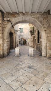 an alley with two benches in a stone building at La Maison De Poupée in Bari