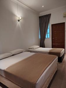 a bedroom with two beds and a window at Pearl Villa 5 Bedroom Unit 6 in Port Dickson