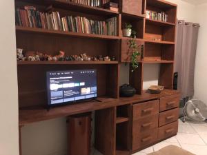 a wooden desk with a computer on top of it at Apartamento com Wifi, Livros e Espaço Pet in Rio das Ostras