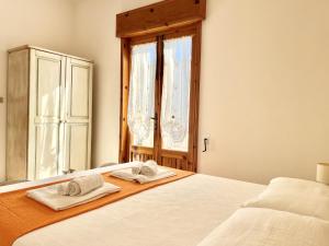 a bedroom with a bed with two towels on it at Front Beach Apartments Rose Superiore in Marina di Pescoluse
