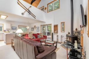 a living room with a red couch and a fireplace at Twin Maples | WiFi, River Access, BBQ in Packwood