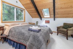 a bedroom with a large bed and a chair at Twin Maples | WiFi, River Access, BBQ in Packwood