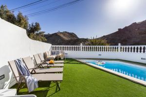 a patio with chairs and a swimming pool at House of dreams in Mogán