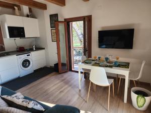 a kitchen and living room with a white table and chairs at Apartamentos Rurales Balisa in Esparza