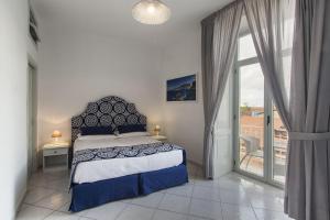 a bedroom with a bed and a large window at Palazzo Starace in Sorrento