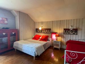 GardonneにあるVaste maison familiale en pierres apparentes PROMO SEPTEMBREのベッドルーム1室(赤い枕のベッド1台付)