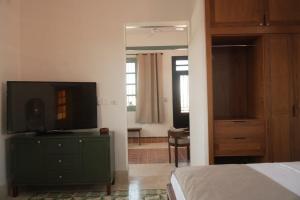 a bedroom with a green dresser with a television on it at Authentic Colonial & Central in Campeche