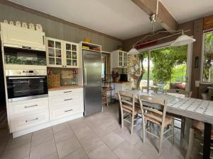 GardonneにあるVaste maison familiale en pierres apparentes PROMO SEPTEMBREの白いキャビネットとテーブルと椅子のあるキッチン +6枚の写真