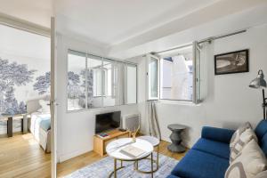 salon z niebieską kanapą i łóżkiem w obiekcie Bel appartement au coeur de Montorgueil w Paryżu