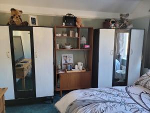 1 dormitorio con cama, espejo y tocador en Mary's Villa, en Felixstowe