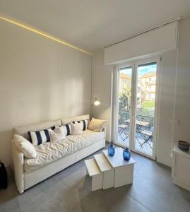 a living room with a white couch and a large window at Casa Biba in Finale Ligure