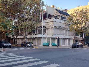 ein weißes Gebäude mit davor geparkten Autos in der Unterkunft Puerto Marina 2 in Buenos Aires