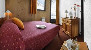ヴァル・トランスにあるAbrineige Le Schuss Val Thorensのピンクベッド1台、テーブル、鏡が備わるベッドルーム1室が備わります。